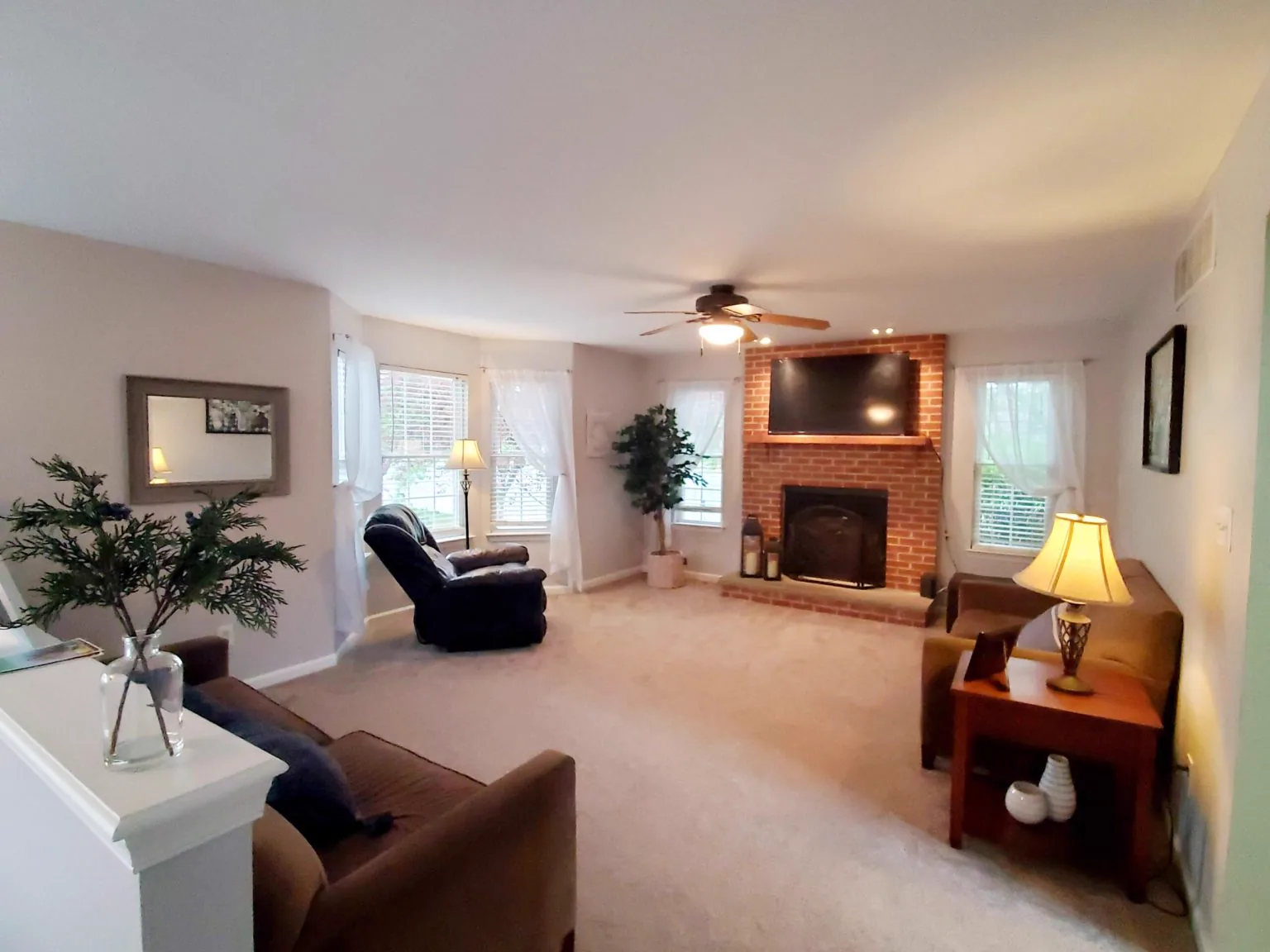 Living room with new carpet, a recliner and a brick fireplace, installed by Carpet and Floors by Eric